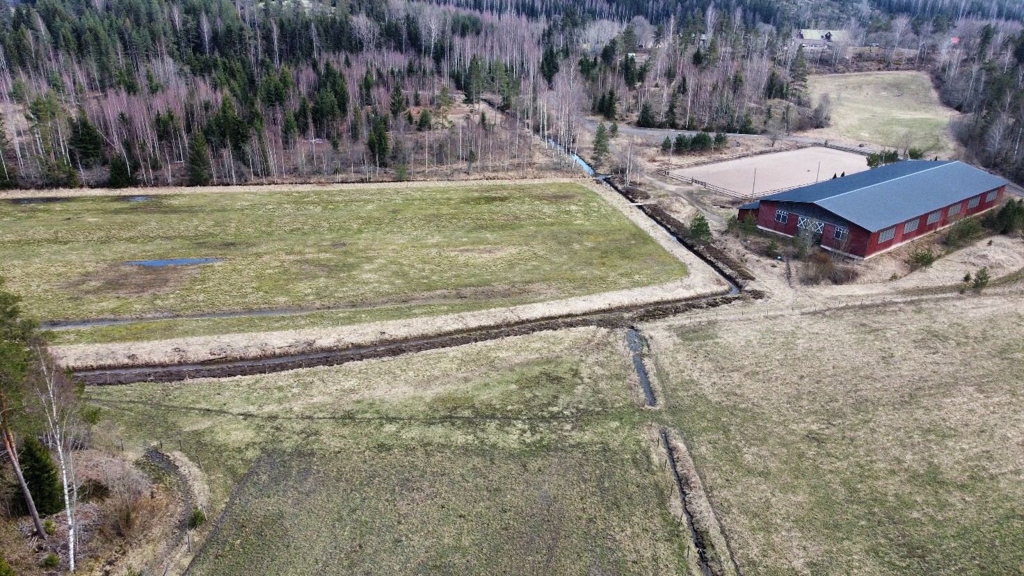 Innanbäck ennen kosteikkoa: kuvassa näkyy peltoja ja ympäröivää metsää ja rakennuksia.