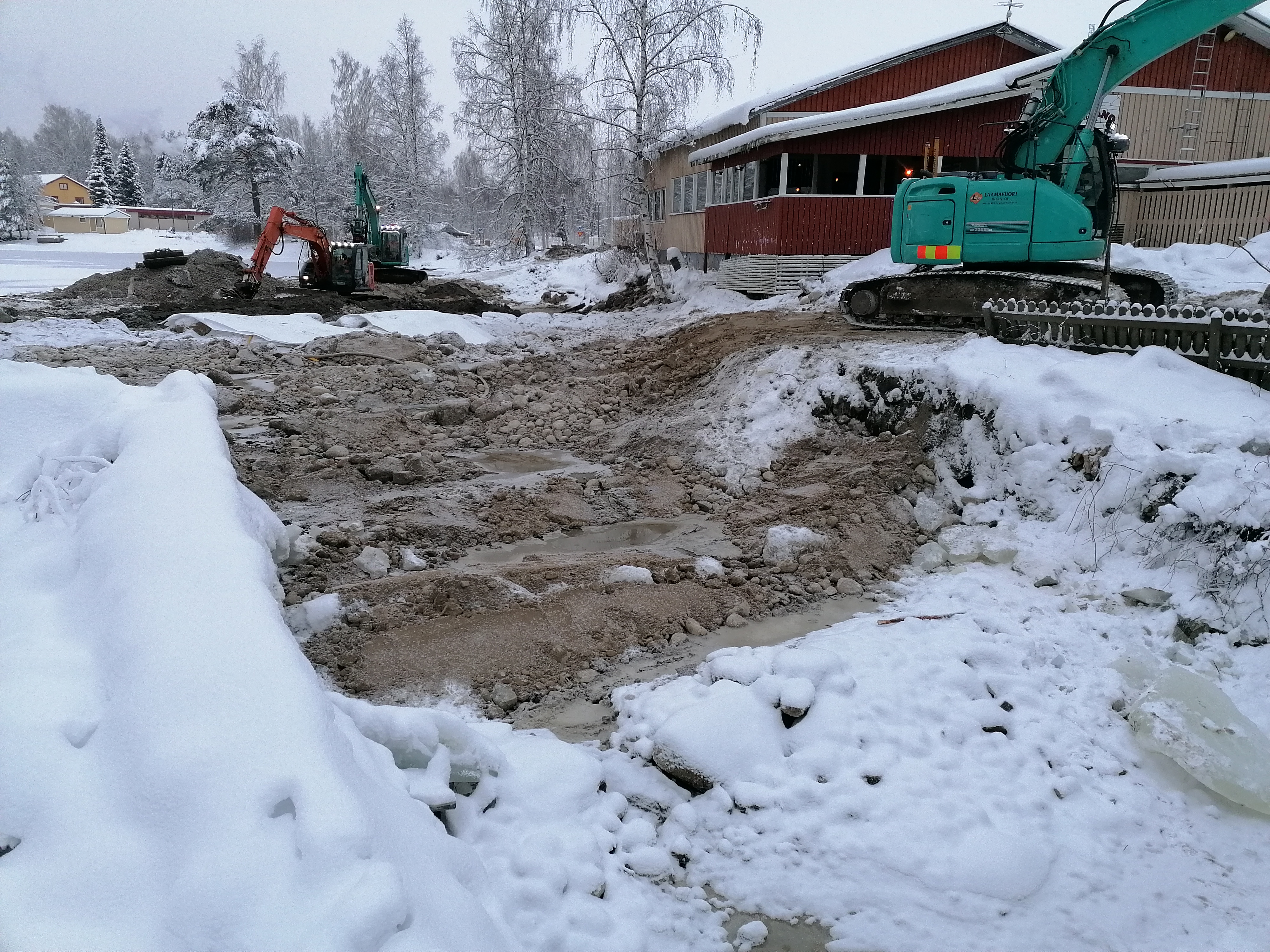 Etualalla patotyömaa, jossa pato poistettu ja kosken pohjaa kynnystetty. Luminen talvinen kuva. Taustalla kaivinkoneita.