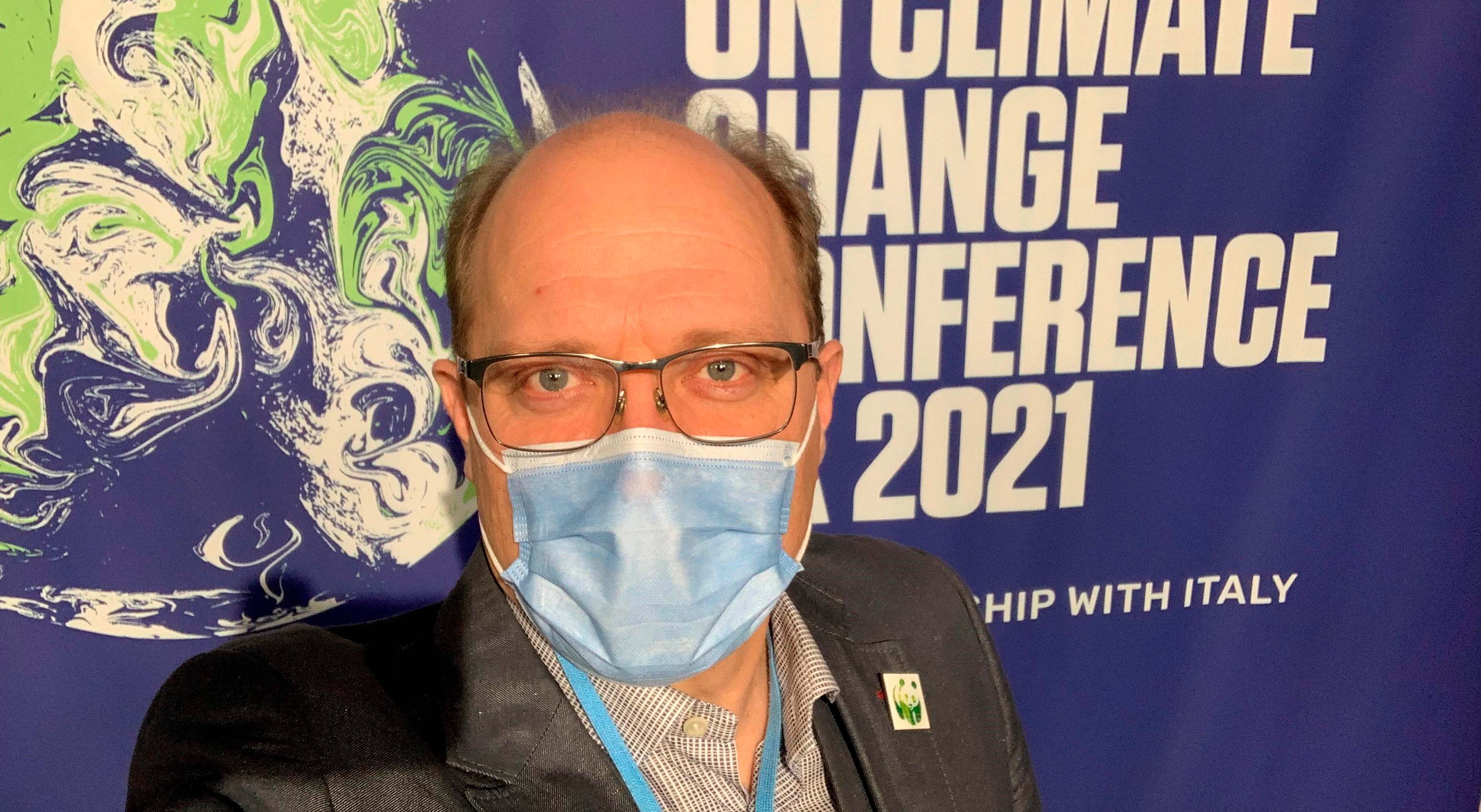 WWF Suomen ilmastoasiantuntija Bernt Nordmanin selfie-kuva taustakankaan edessä Glasgow'n ilmastokokouksessa.
