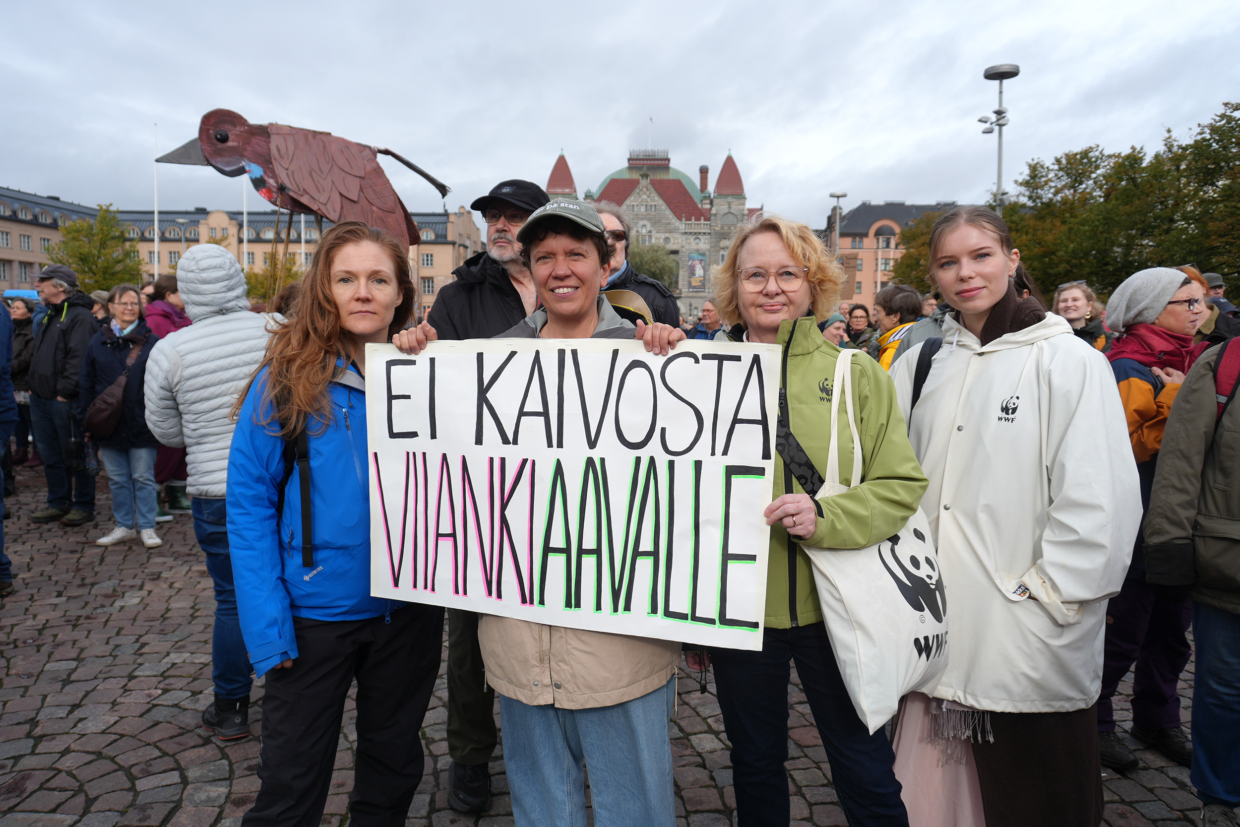WWF:n työntekijät pitelevät mielenosoituksessa kylttiä, jossa lukee 